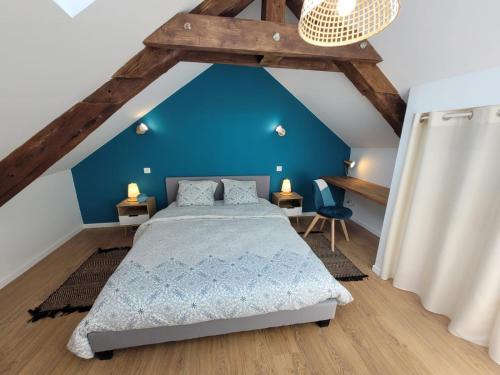 um quarto com uma cama e uma parede azul em L'Azimut de Châtel-Guyon em Châtel-Guyon