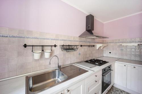 a kitchen with a sink and a stove at Appartamento La Buraggia in Diano San Pietro