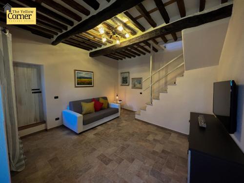 sala de estar con sofá y escalera en Yellow Corner, en Bagni di Lucca