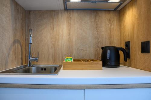 a kitchen with a sink and a coffee pot on a counter at CUBES ON THE BEACH Athens Airport in Artemida