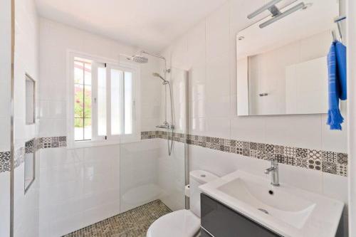 Baño blanco con lavabo y aseo en Casa ladera II en Torrox