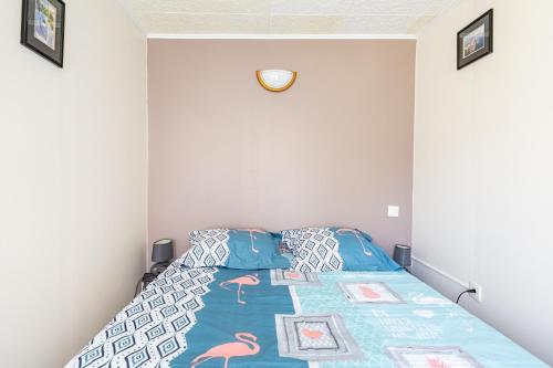 una camera da letto con un letto con un piumone blu di Le Quiloé a Frontignan