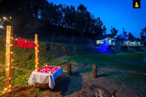 una mesa con corazones rojos en un campo por la noche en LivingStone Shimla Jungle Stay, en Shimla