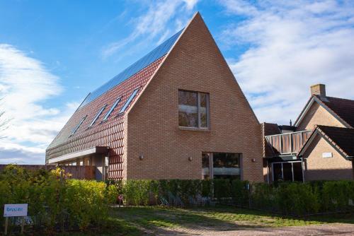a large brick building with a pyramid shaped roof at Breeze Ameland in Hollum