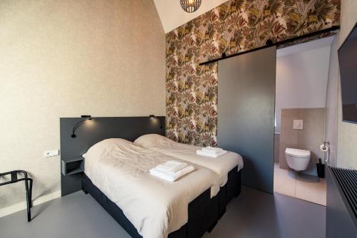 a bedroom with a bed and a bathroom with a toilet at Breeze Ameland in Hollum