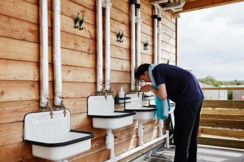 a man standing in front of a wall of sinks at The Camp at The Wave in Bristol