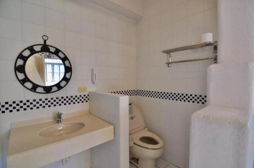 a bathroom with a toilet and a sink and a mirror at Village Villa B&B in Zhuqi