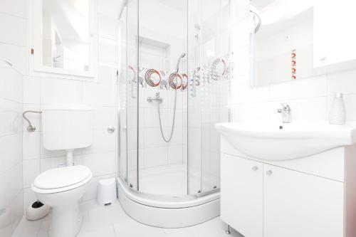 a white bathroom with a shower and a toilet and a sink at Apartment Morris in Veli Lošinj