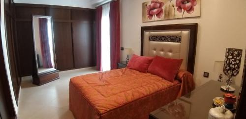 a bedroom with a bed with red pillows on it at APARTAMENTO REFORMADO Y LUMINOSO EN AGUILAR DE LA FRONTERA in Aguilar de la Frontera
