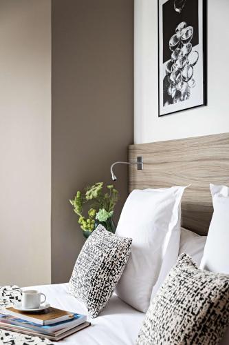 a bedroom with a bed with white pillows and a table at Best Western Paris Porte de Versailles in Issy-les-Moulineaux