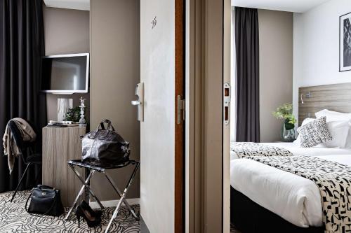 a hotel room with a bed and a television at Best Western Paris Porte de Versailles in Issy-les-Moulineaux