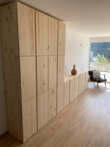 pared de paneles de madera en una habitación con silla en Traumapartment Murmeltier Tirol, en Grins