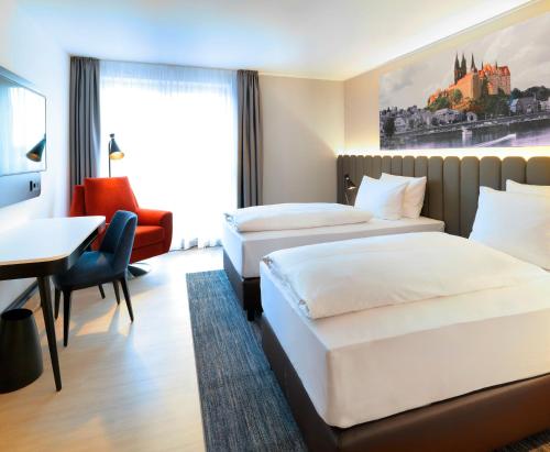 a hotel room with two beds and a desk at Radisson Blu Park Hotel & Conference Centre in Dresden