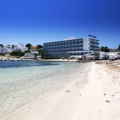 a view of the beach with a hotel in the background at Hotel Argos Ibiza in Talamanca