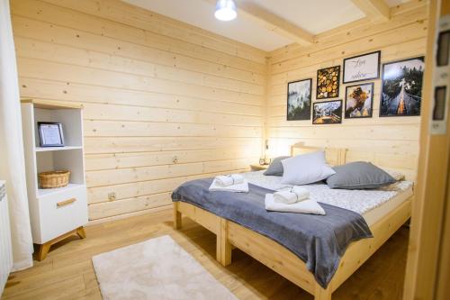 een slaapkamer met een bed in een houten kamer bij Apartament Kierunek Tatry in Bukowina Tatrzańska