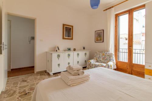 sypialnia z łóżkiem, krzesłem i oknem w obiekcie Casa Caterina w mieście Pozzallo