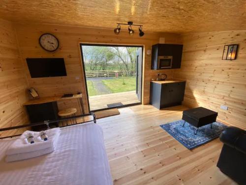 トーントンにあるLakeside Lodgeのベッドと壁に時計がある部屋