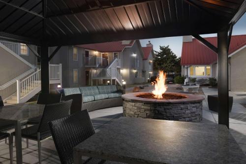 a patio with a fire pit with tables and chairs at Sonesta ES Suites Albuquerque in Albuquerque