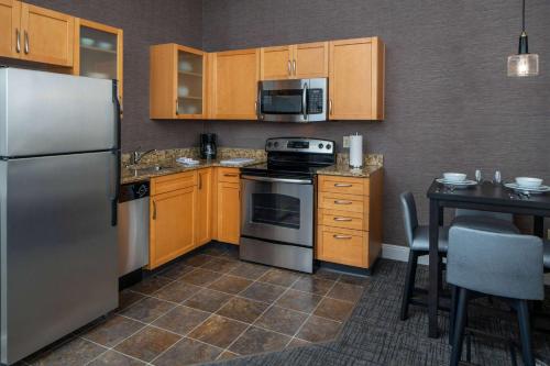 a kitchen with stainless steel appliances and wooden cabinets at Sonesta ES Suites New Orleans Convention Center in New Orleans