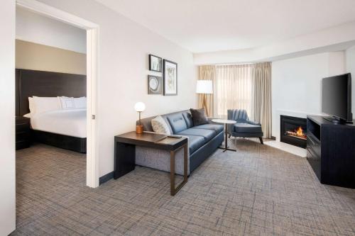 a hotel room with a bed and a couch and a television at Sonesta ES Suites Atlanta Kennesaw Town Center in Kennesaw