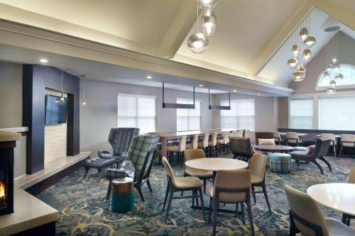 a restaurant with tables and chairs and a fireplace at Sonesta ES Suites Raleigh Cary in Cary