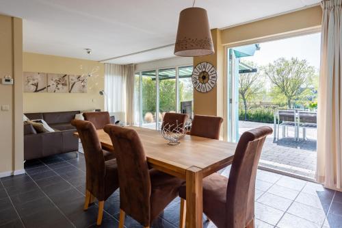 ein Esszimmer mit einem Holztisch und Stühlen in der Unterkunft Bandol 186 - Kustpark Village Scaldia in Hoofdplaat