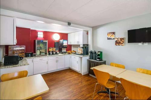 a kitchen with white cabinets and a table and chairs at Super 8 by Wyndham Charleston WV in Charleston
