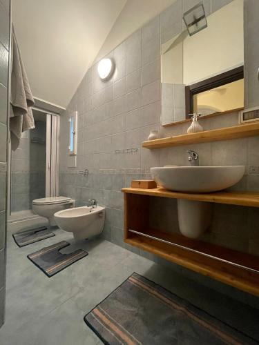 a bathroom with two sinks and a toilet and a mirror at B&B Dimora Villa Orietta - Torre dell'Orso in Torre dell'Orso