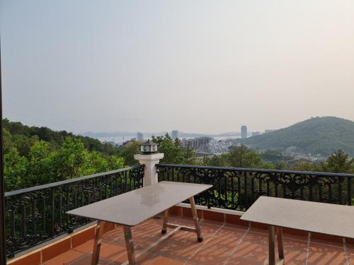 een balkon met een tafel en twee banken erop bij Little Cloudy on the hilltop in Ha Long