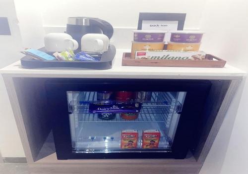 a small refrigerator with food and drinks on a shelf at Park Inn by Radisson Surat in Surat