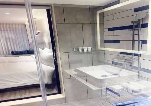 a bathroom with a glass shower and a bed at Park Inn by Radisson Surat in Surat