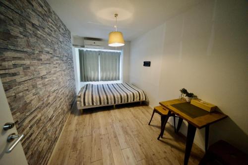 Pokój z ławką i ceglaną ścianą w obiekcie Guest House Re-worth Yabacho1 302 w mieście Nagoja