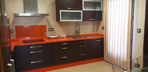 eine Küche mit braunen Schränken und einem Waschbecken in der Unterkunft APARTAMENTO REFORMADO Y LUMINOSO EN AGUILAR DE LA FRONTERA in Aguilar de la Frontera