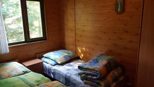 Habitación con 2 camas en una cabaña de madera en Ośredek Wypoczynkowy MEDUSA, en Rusinowo