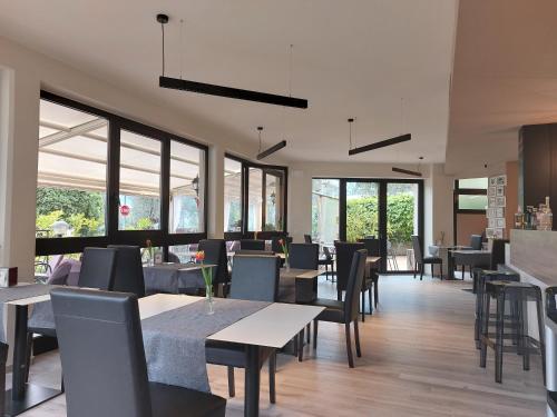 ein Restaurant mit Tischen, Stühlen und Fenstern in der Unterkunft Hotel Villa Grazia in Limone sul Garda
