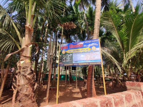 a sign in front of a bunch of palm trees at Rama Niwas Beach Home Stay in Pawas
