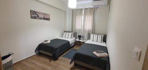 a small room with two beds and a table at Markellas Apartment in Ampavris
