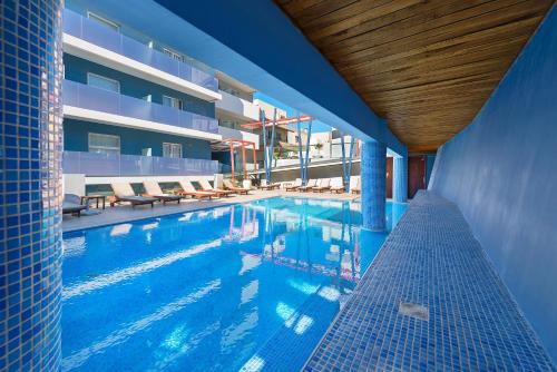 una piscina con sillas y un edificio en Semiramis City Hotel, en Rodas