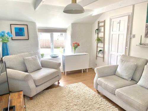 a living room with two chairs and a couch at Idyllic Cornish Cottage, Superking bed, private garden dogs welcome in Truro