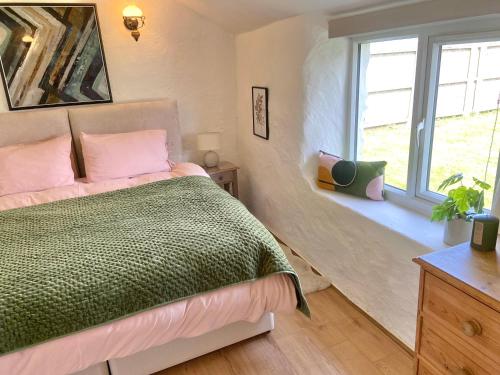 Rúm í herbergi á Idyllic Cornish Cottage, Superking bed, private garden dogs welcome