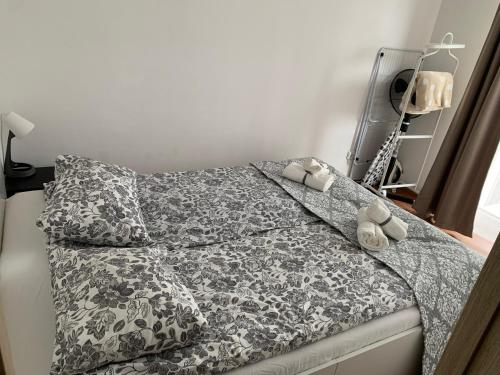 a bed with a black and white comforter and pillows at Ozas Apartment 1 and 2 in Vilnius
