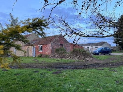 un coche azul estacionado frente a una casa de ladrillo en Amazingly quiet and peaceful studio getaway., en Woodhall Spa