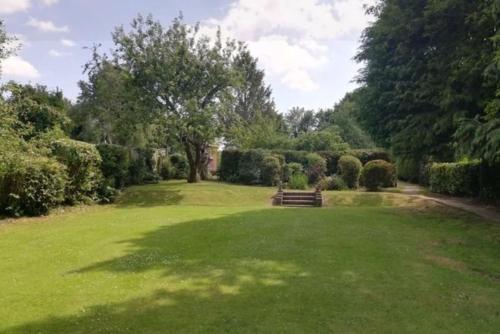a park with a bench in the middle of a field at Sycamore Lodge Kent With EV Zappi type 2, swimming pool for a fee in Sellindge
