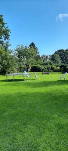 a park with two benches in a green field at Sycamore Lodge Kent With EV Zappi type 2, swimming pool for a fee in Sellindge