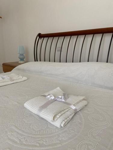 a bed with two white towels on top of it at I Trulli del Mulino in Locorotondo