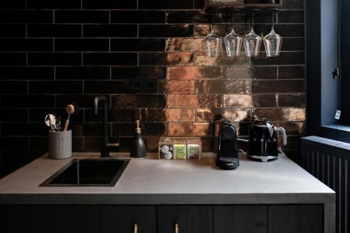 a kitchen counter with a sink and a brick wall at B&B De Edelsmederij in Schoonhoven