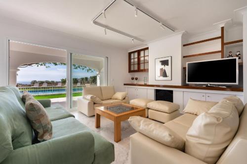 Una televisión o centro de entretenimiento en Villa Can Joan I - Fantastic Sunset Views and Family Friendly -