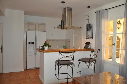une cuisine avec deux tabourets de bar et un comptoir dans l'établissement Villa Côte & Provence - private heated pool, à Fayence