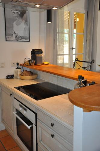 a kitchen with a counter with a stove top oven at Villa Côte & Provence - private heated pool in Fayence