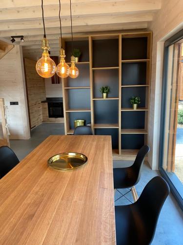 a dining room with a wooden table and chairs at Mazurskie Klimaty - dom z widokiem na jezioro in Tomaszkowo